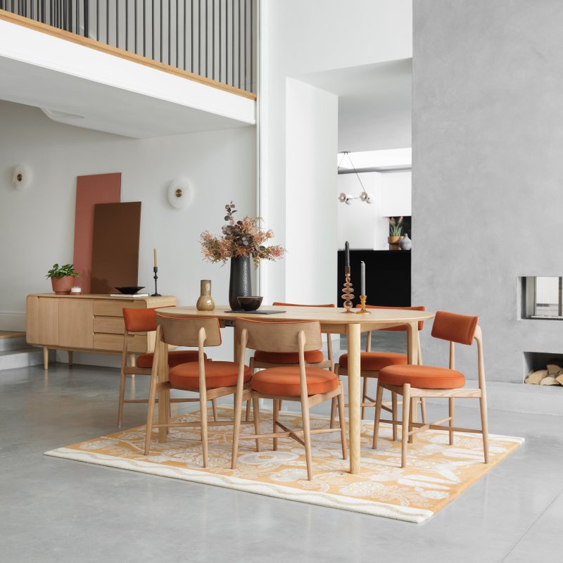 G Plan Winchester Oval Extending Dining Table And 6 Orange Flora Chairs lifestyle image of the dining set